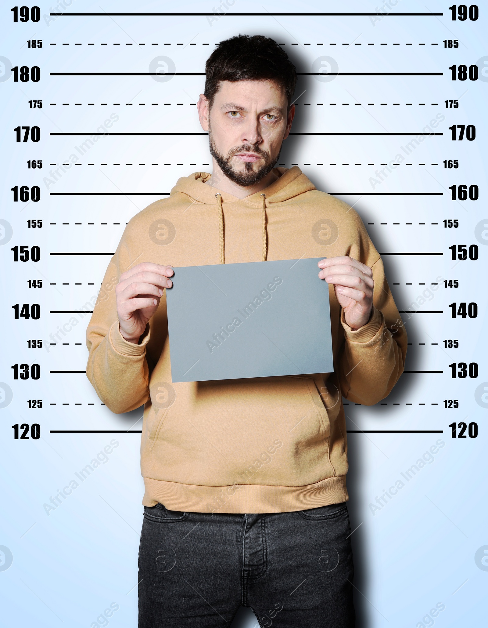 Image of Criminal mugshot. Arrested man with blank card against height chart