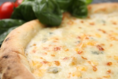 Photo of Delicious cheese pizza and basil on table, closeup