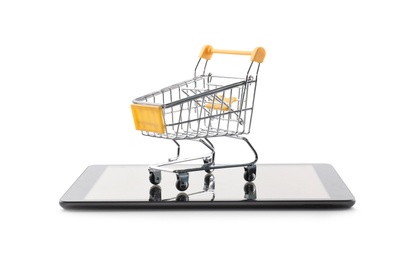 Internet shopping. Small cart and modern tablet on white background