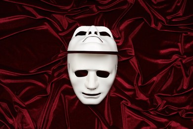 Theater arts. White masks on red fabric, top view