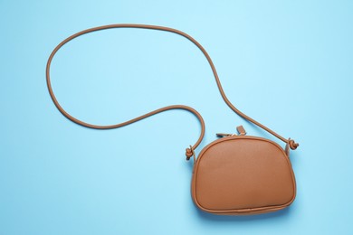 Photo of Stylish woman's bag on light blue background, top view
