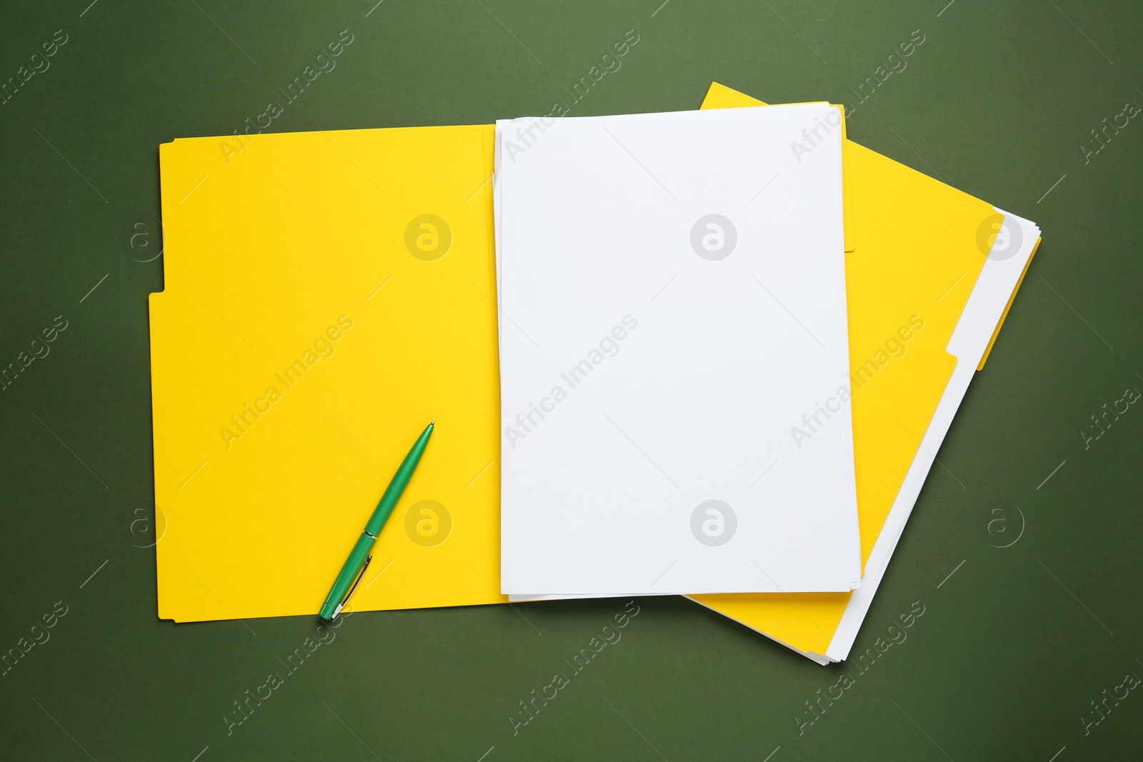 Photo of Yellow files with blank sheets of paper and pen on dark green background, top view. Space for design