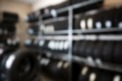 Photo of Blurred view of tires on racks in automobile service center