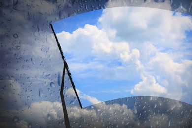 Image of Car windshield wiper cleaning water drops from glass