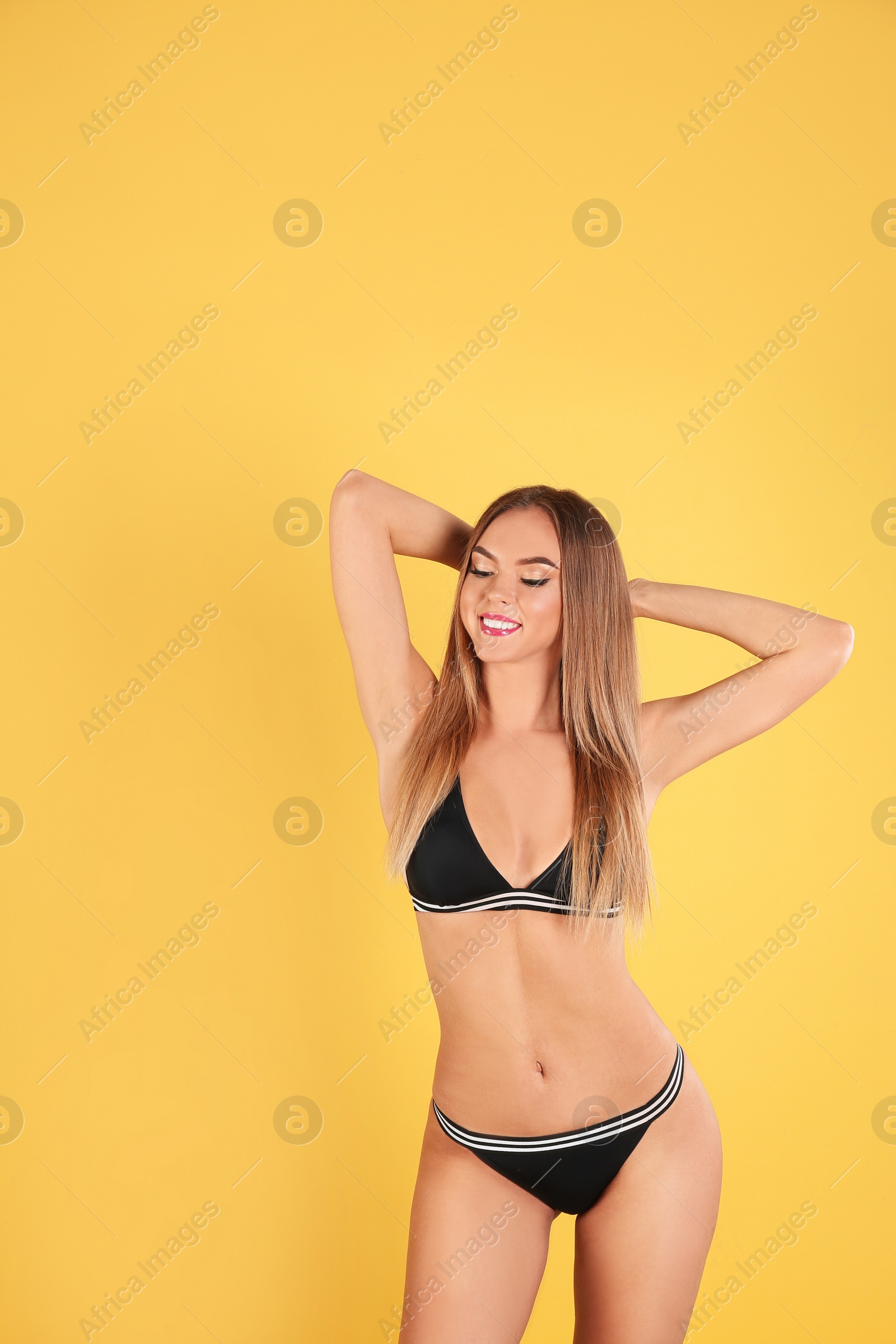 Photo of Pretty sexy woman with slim body in stylish bikini on color background, space for text