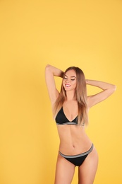 Pretty sexy woman with slim body in stylish bikini on color background, space for text