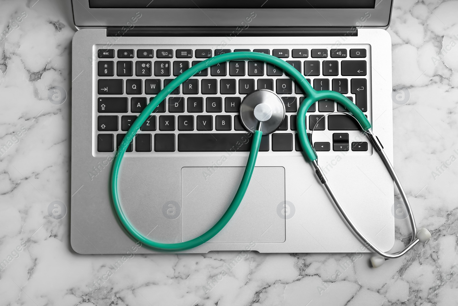 Photo of Keyboard and stethoscope on white marble table, flat lay. Concept of technical support