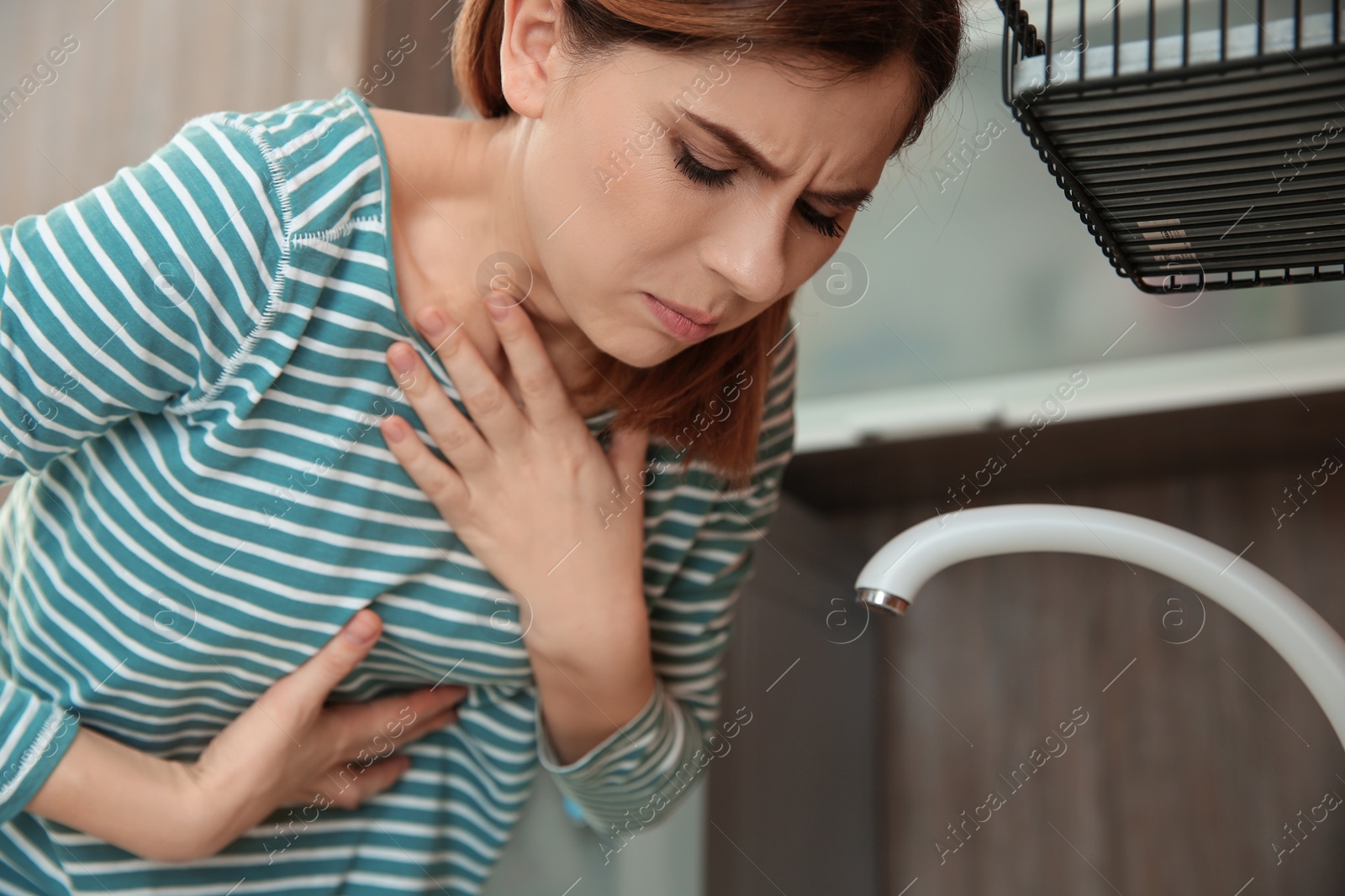 Photo of Young woman suffering from morning sickness at home