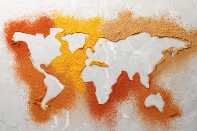 World map of different spices on light grey marble table, flat lay