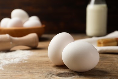 Photo of Raw chicken eggs on wooden table, closeup. Space for text