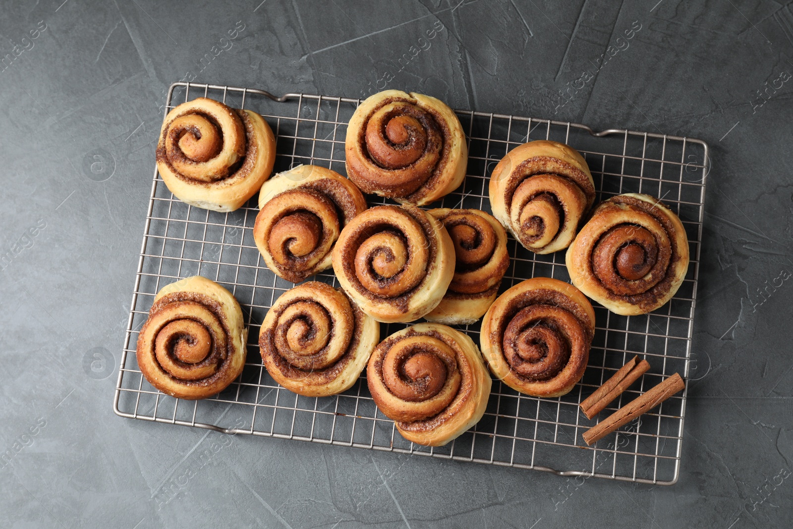 Photo of Tasty cinnamon rolls on black table, top view