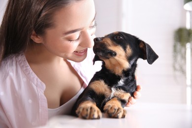 Photo of Woman with cute puppy indoors. Lovely pet