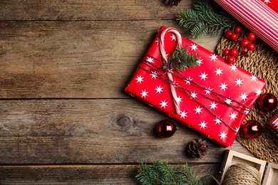 Photo of Flat lay composition with beautifully wrapped gift box on wooden table, space for text