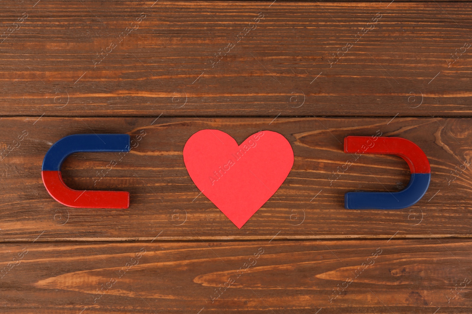 Photo of Magnets and red heart on wooden table, flat lay