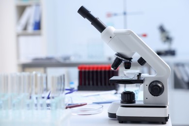 Photo of Modern medical microscope on white table in laboratory. Space for text