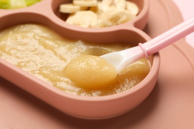 Photo of Healthy baby food. Section plate with delicious apple puree and fruit on table, closeup