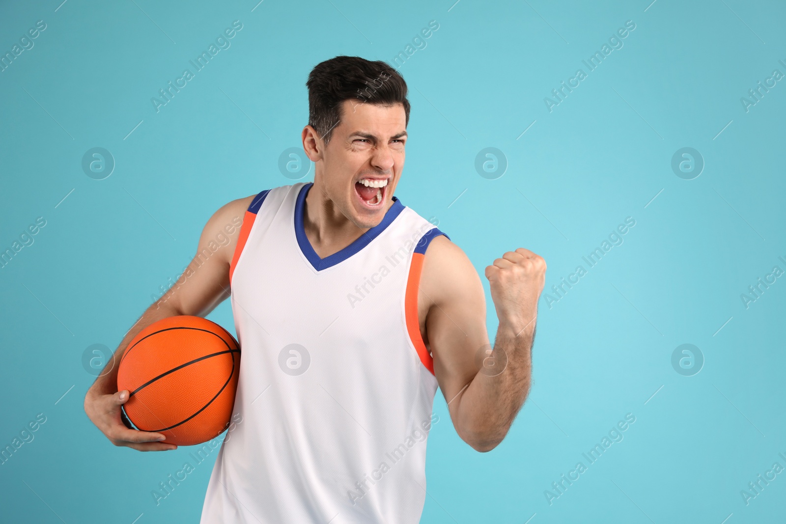 Photo of Basketball player with ball on light blue background