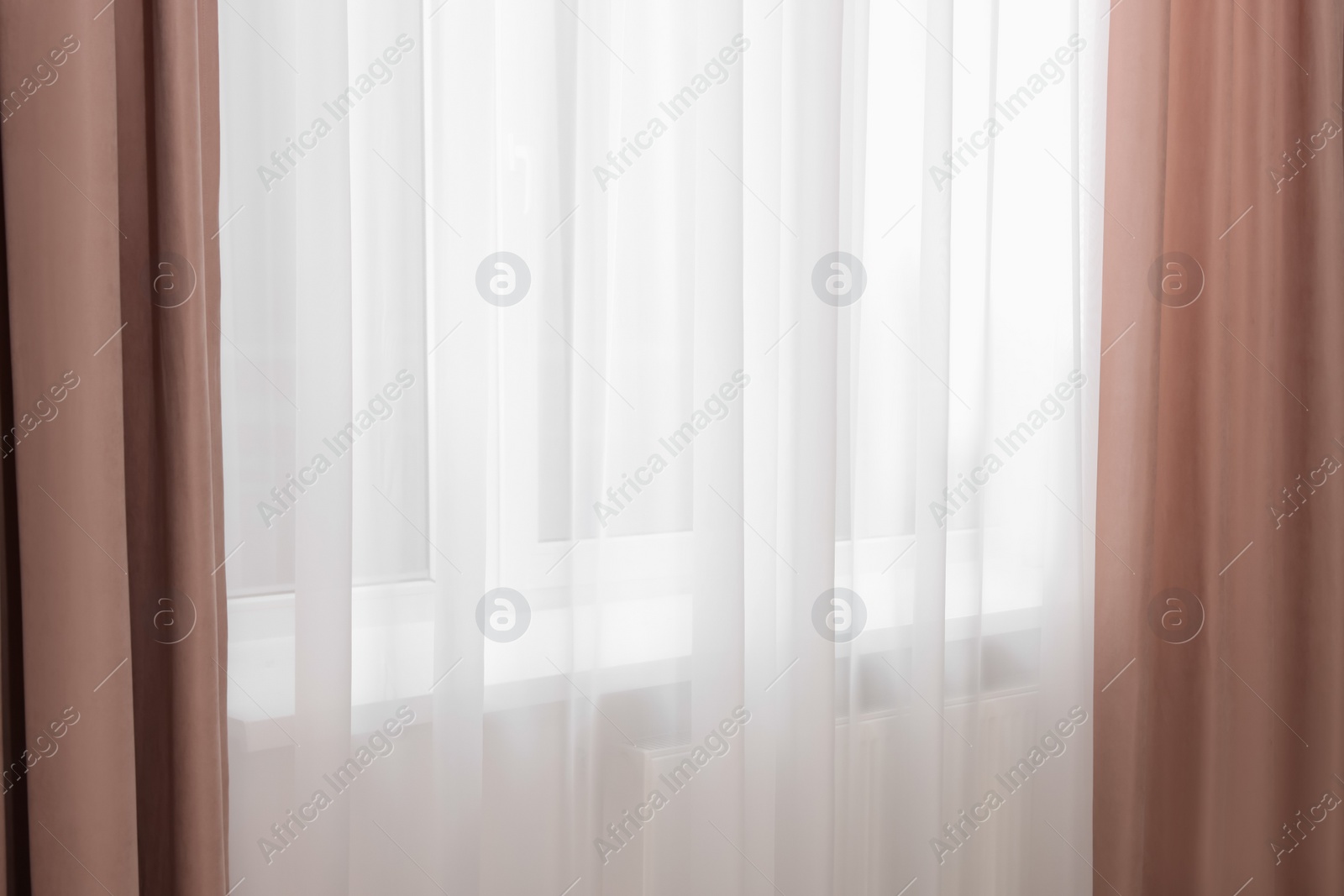 Photo of Elegant window curtains and white tulle indoors. Interior design