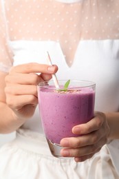 Photo of Woman with glass of delicious blackberry smoothie, closeup