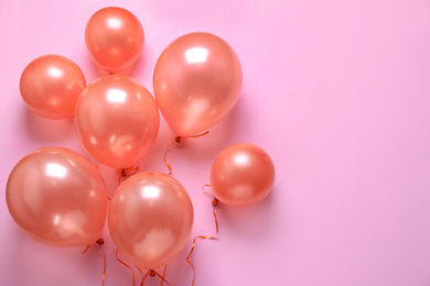 Photo of Colorful balloons on pink background, flat lay. Space for text