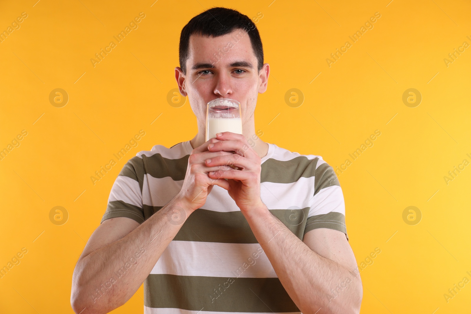 Photo of Milk mustache left after dairy product. Man drinking milk on orange background