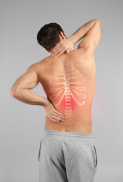 Image of Man suffering from pain in back on light grey background