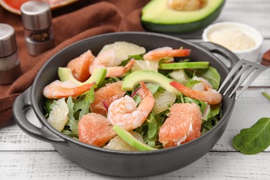 Delicious pomelo salad with shrimps served on white wooden table, closeup