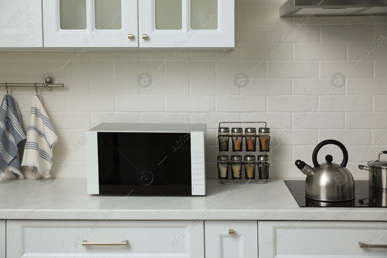 Photo of Modern microwave oven on countertop in kitchen