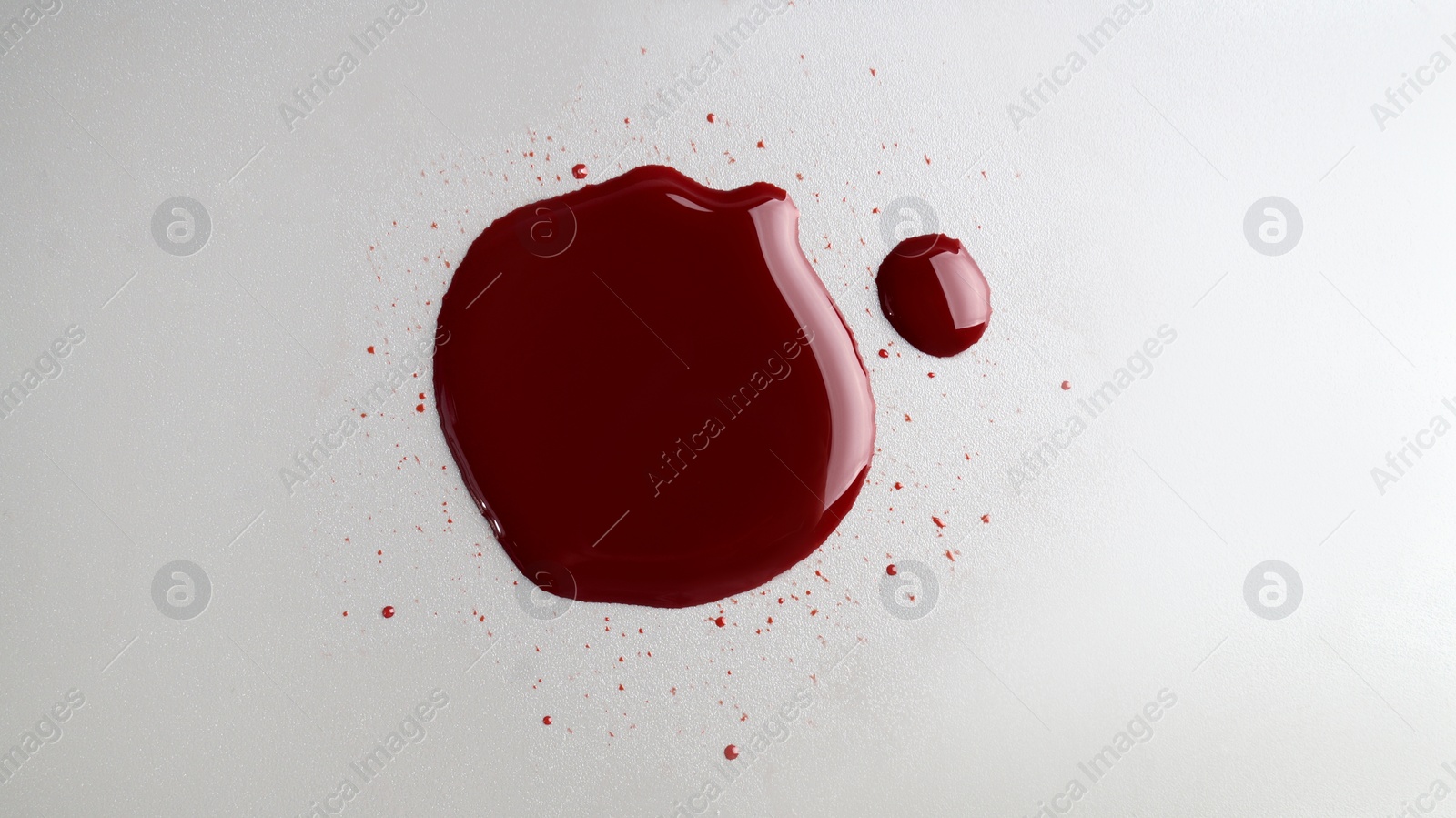 Photo of Stain of blood on light grey background, top view