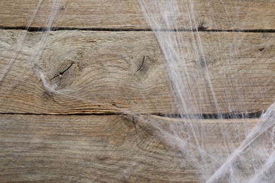 Creepy white cobweb hanging on wooden wall