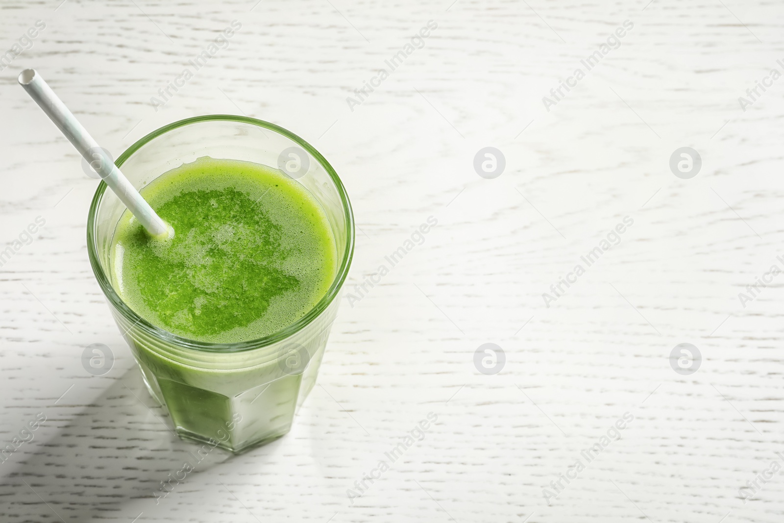 Photo of Glass with delicious detox juice on light background