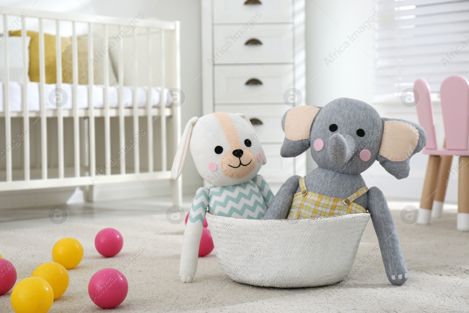 Photo of Cute toys on floor in baby room. Interior elements