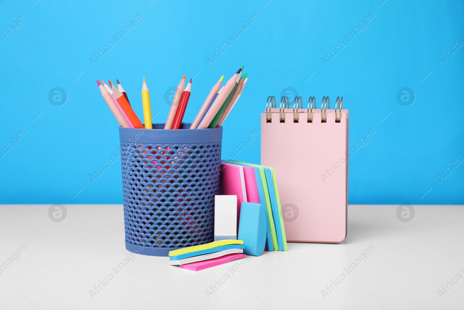 Photo of Different school stationery on white table against light blue background. Back to school
