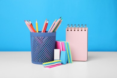 Different school stationery on white table against light blue background. Back to school