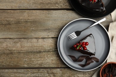 Photo of Tasty homemade chocolate cake with berries and mint served on wooden table, flat lay. Space for text