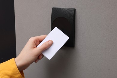 Photo of Woman opening magnetic door lock with key card, closeup. Home security