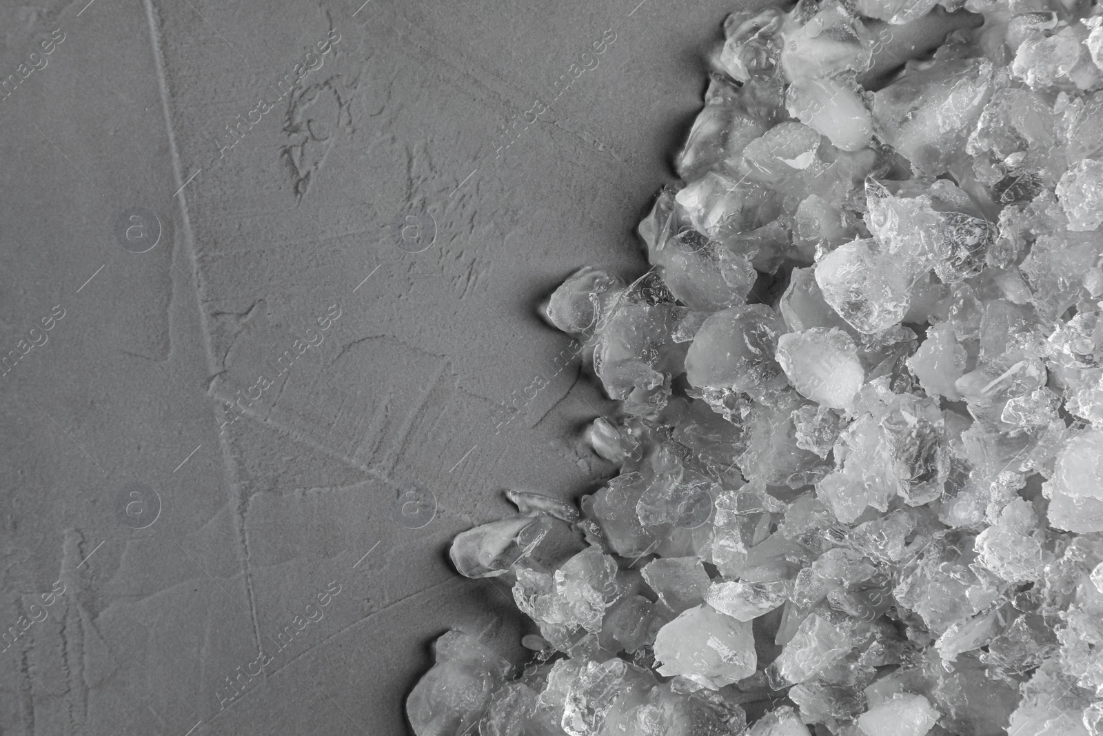 Photo of Heap of crushed ice on grey table, top view. Space for text