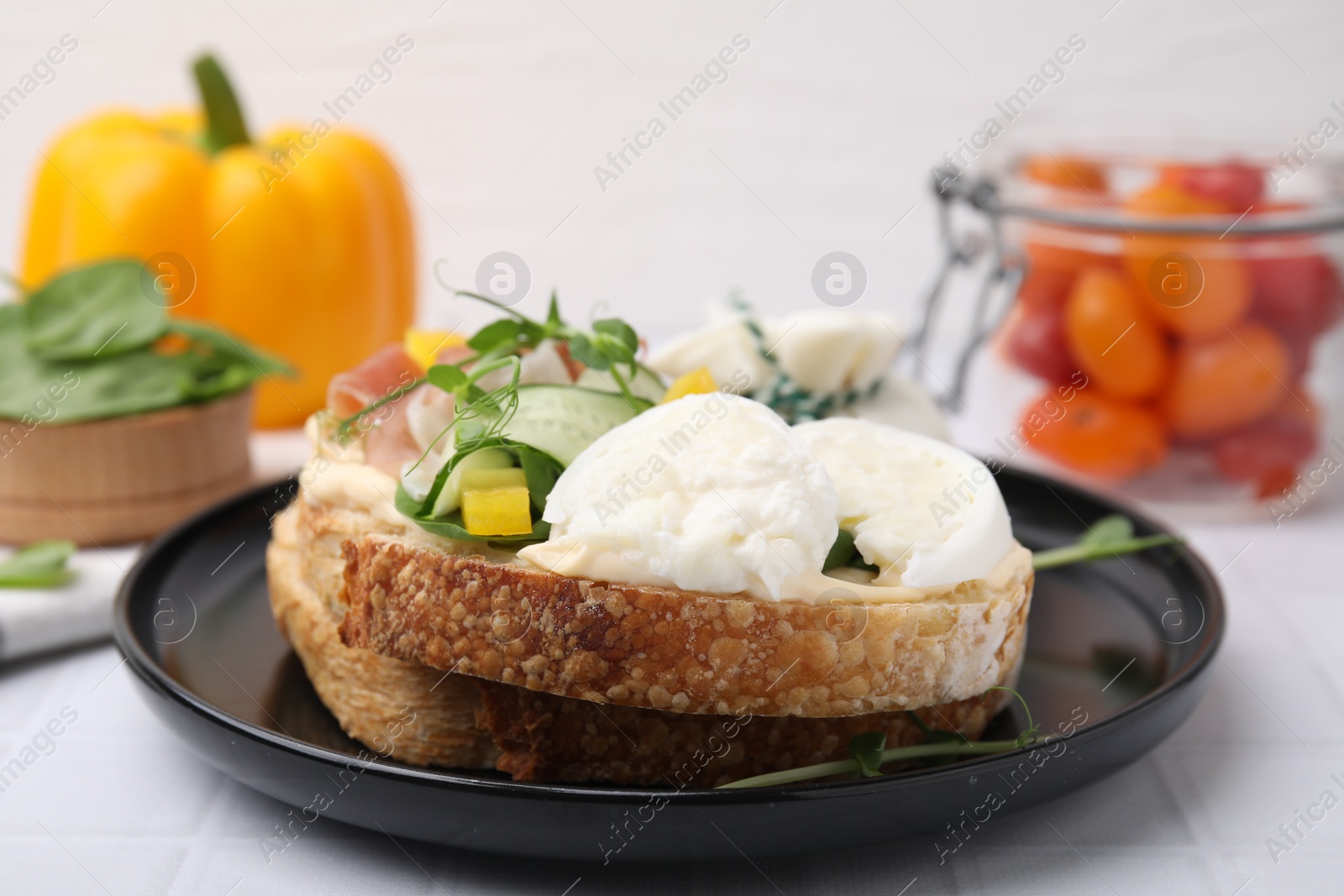 Photo of Tasty sandwich with burrata cheese and vegetables on white table, closeup