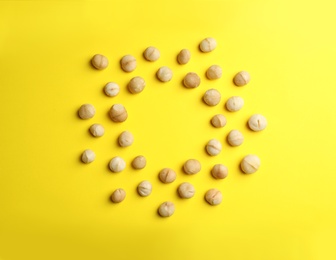 Photo of Frame made of shelled organic Macadamia nuts on color background, top view. Space for text