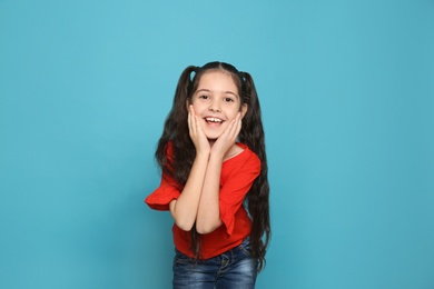 Portrait of little girl laughing on color background