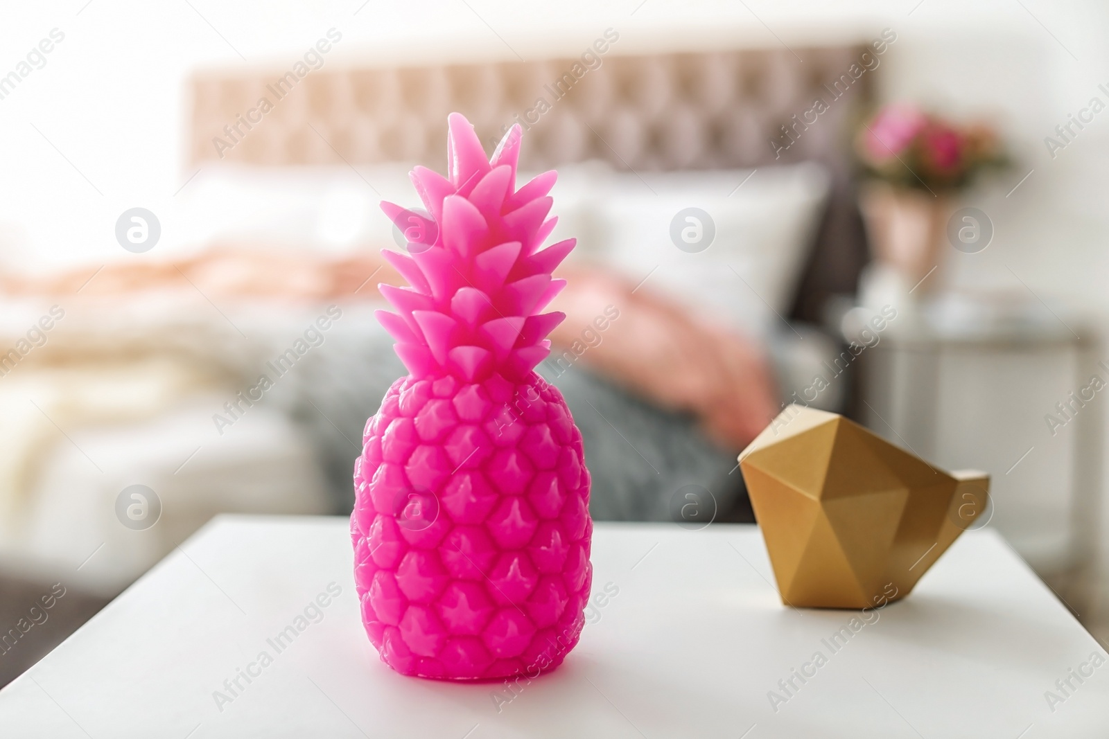 Photo of Pineapple shaped candle on table in room