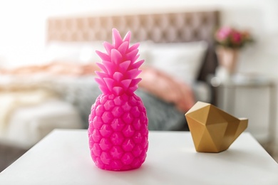 Photo of Pineapple shaped candle on table in room