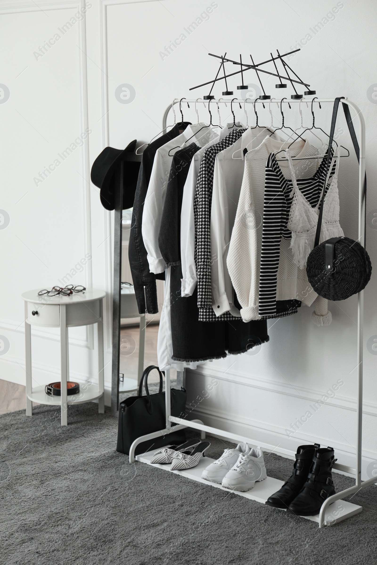 Photo of Rack with stylish clothes in modern dressing room