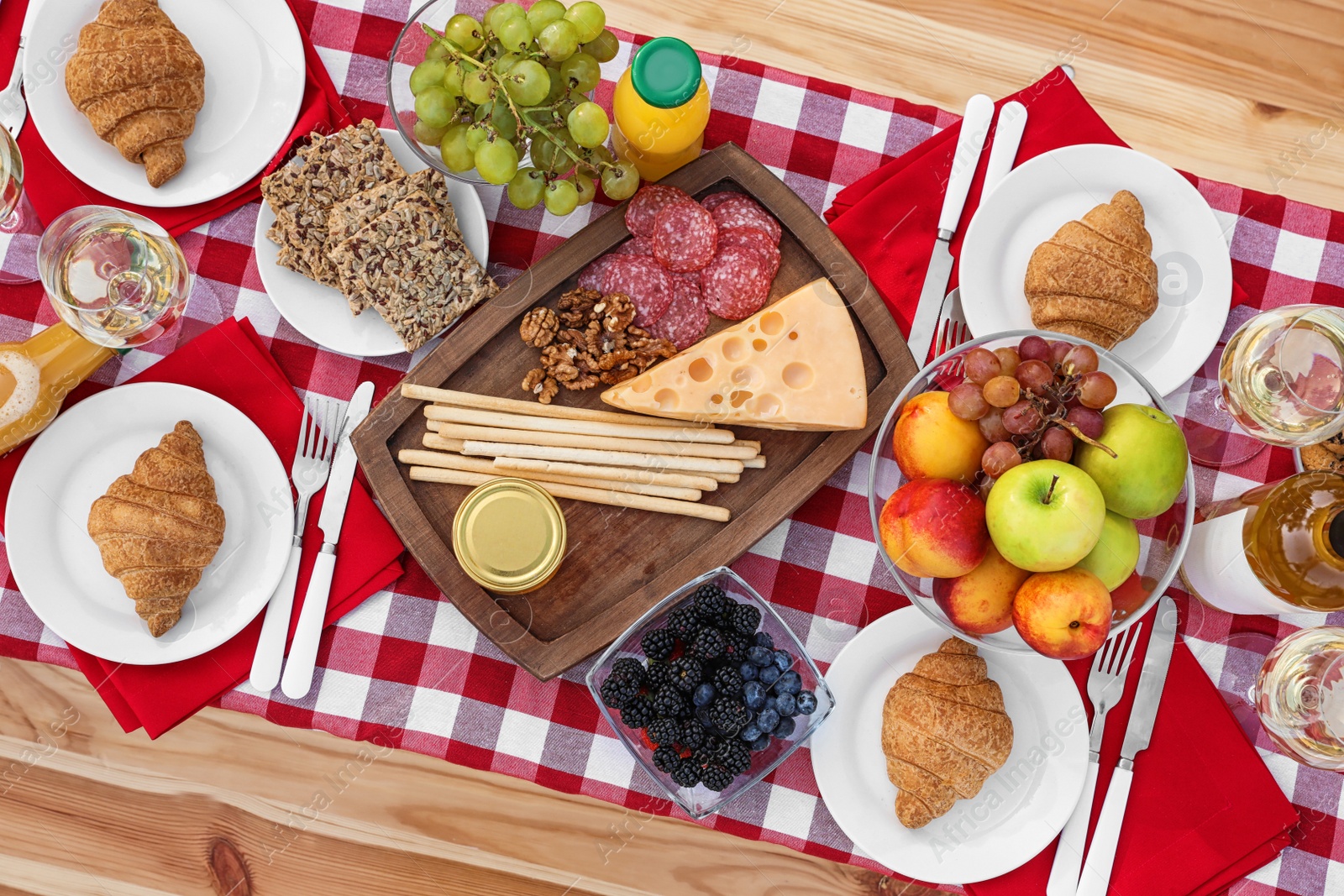 Photo of Picnic table with different tasty snacks and wine, top view