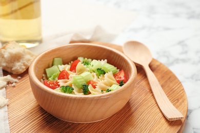 Photo of Wooden bowl with delicious pasta primavera on table