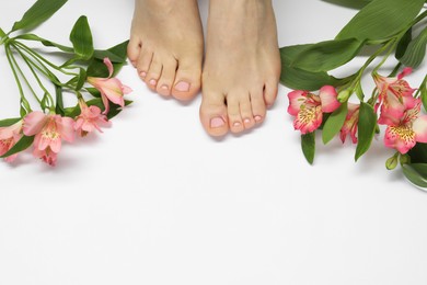 Closeup of woman with neat toenails after pedicure procedure on white background, top view. Space for text