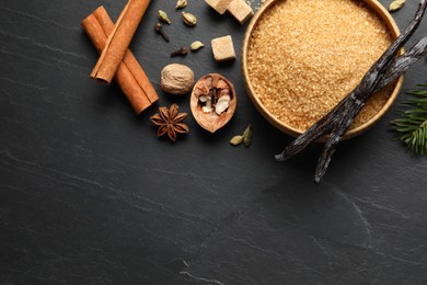 Photo of Different aromatic spices on dark textured table, flat lay. Space for text