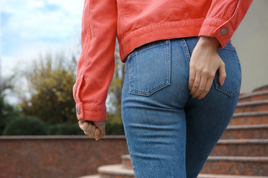 Photo of Woman suffering from hemorrhoid pain outdoors, closeup