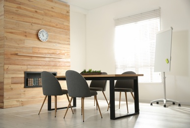 Photo of Modern meeting room interior with large table and chairs