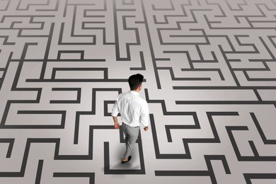 Image of Thoughtful businessman and illustration of maze on light background